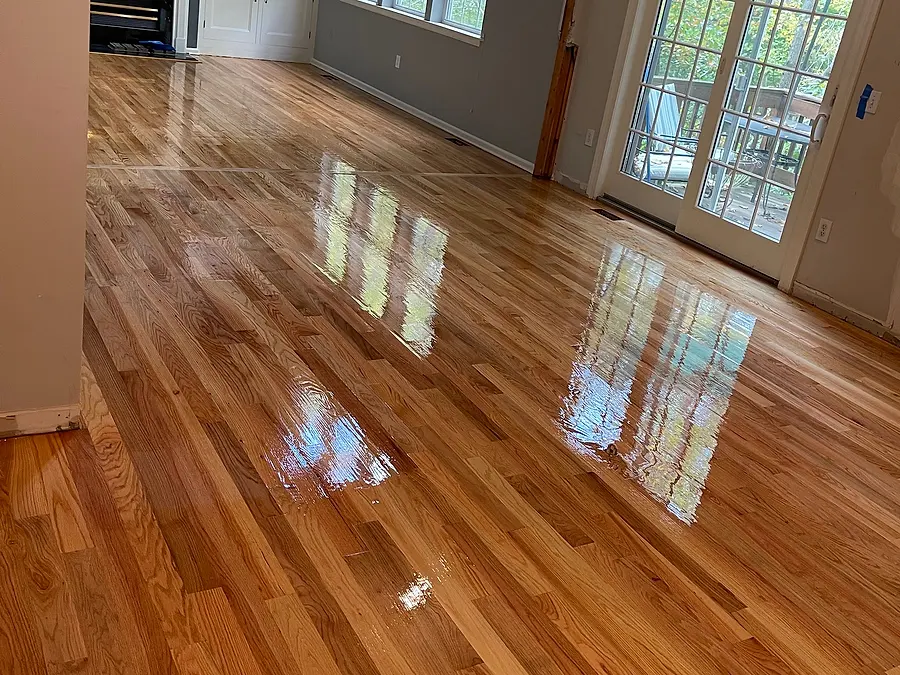 Living room hardwood floor after sanding and refinishing, glossy finish