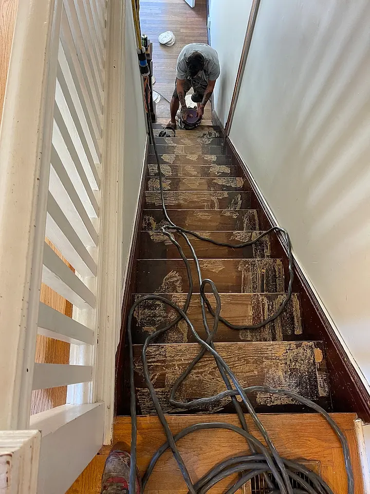 VGJ crew sanding the old finish off a hardwood staircase